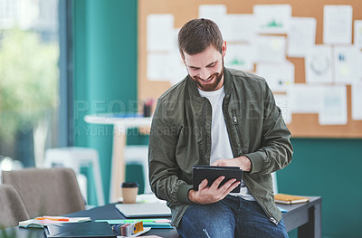 Buy stock photo Shot of a young designer using a digital tablet in an office