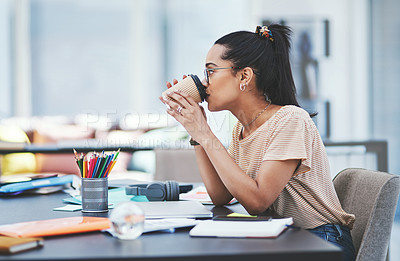 Buy stock photo Shot of a young designer drinking coffee while working in an office
