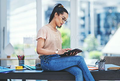 Buy stock photo Shot of a young designer using a digital tablet in an office