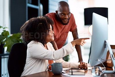 Buy stock photo Shot of two young designers looking at something on a computer screen