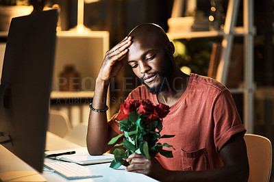 Buy stock photo Shot of a businessman looking at a bunch of roses while working late at the office
