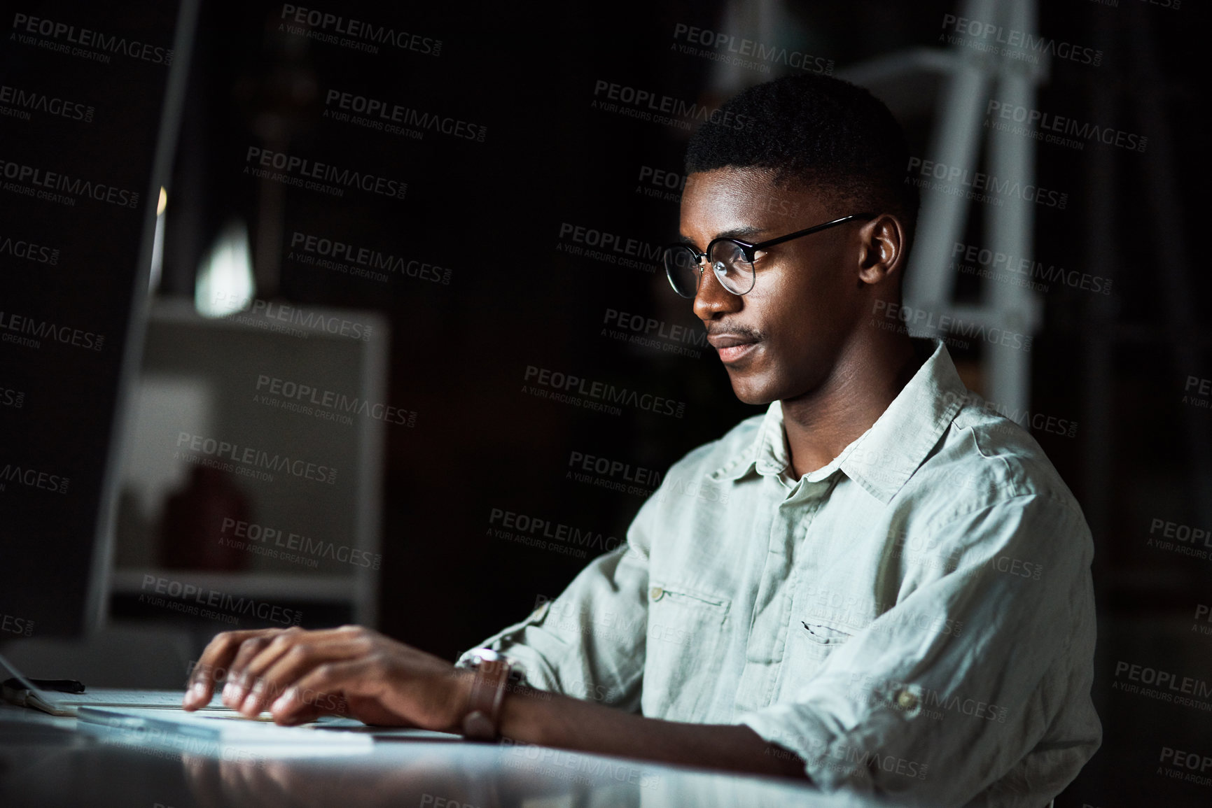 Buy stock photo Cropped shot of a business man using his computer while working late at the office