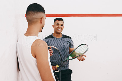 Buy stock photo Shot of two young men chatting after playing a game of squash