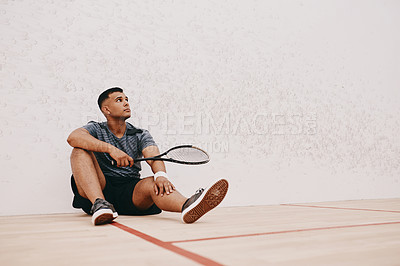 Buy stock photo Shot of a young man taking a break after playing a game of squash