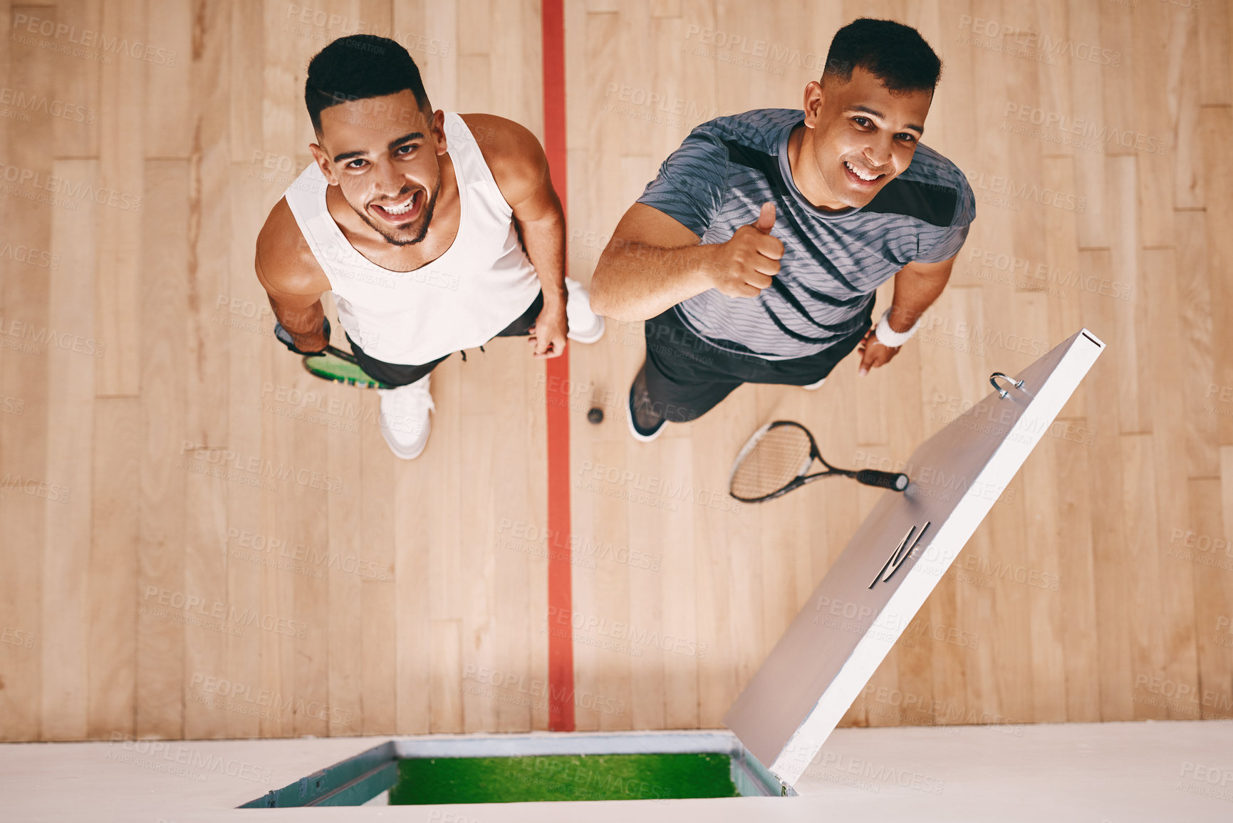 Buy stock photo High angle shot of two young men showing thumbs up at a squash court