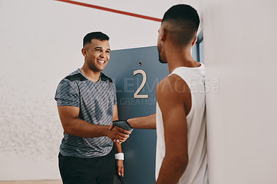 Buy stock photo Shot of two young men shaking hands at a squash court