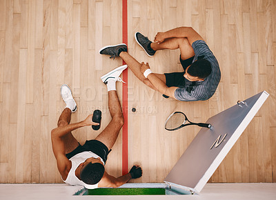 Buy stock photo Shot of two young men chatting during a break at a squash court