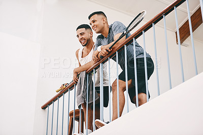 Buy stock photo Shot of two young men watching a game of squash from the viewing gallery