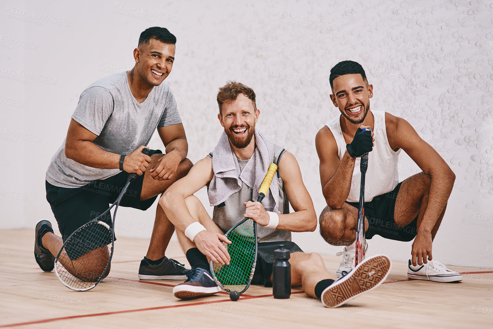 Buy stock photo Shot of three young men playing a game of squash