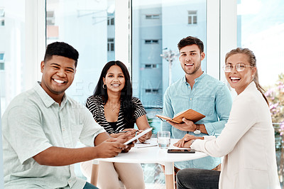 Buy stock photo Cropped portrait of a group of young business colleagues gathered around a table in their office