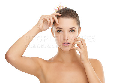 Buy stock photo Cropped portrait of a gorgeous young woman touching her face while posing against a white background