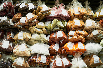 Buy stock photo Shot of a wide variety of different types of spices grouped together at a market stall outside during the day