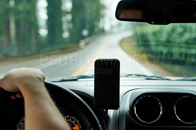 Buy stock photo Cropped shot of a man using his phone’s gps system while driving a car