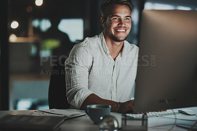 Buy stock photo Shot of a young businessman working on a computer in an office at night