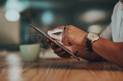 Buy stock photo Closeup shot of an unrecognisable businessman using a digital tablet in an office at night