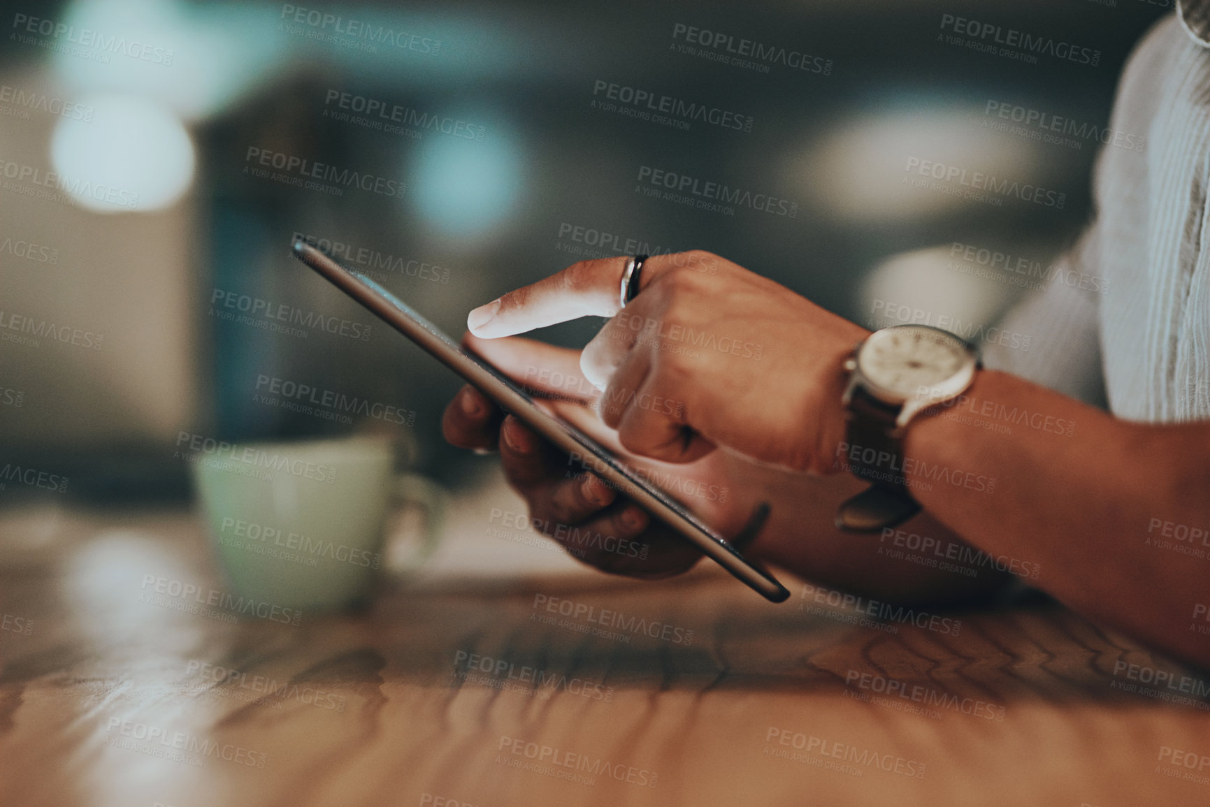Buy stock photo Closeup shot of an unrecognisable businessman using a digital tablet in an office at night