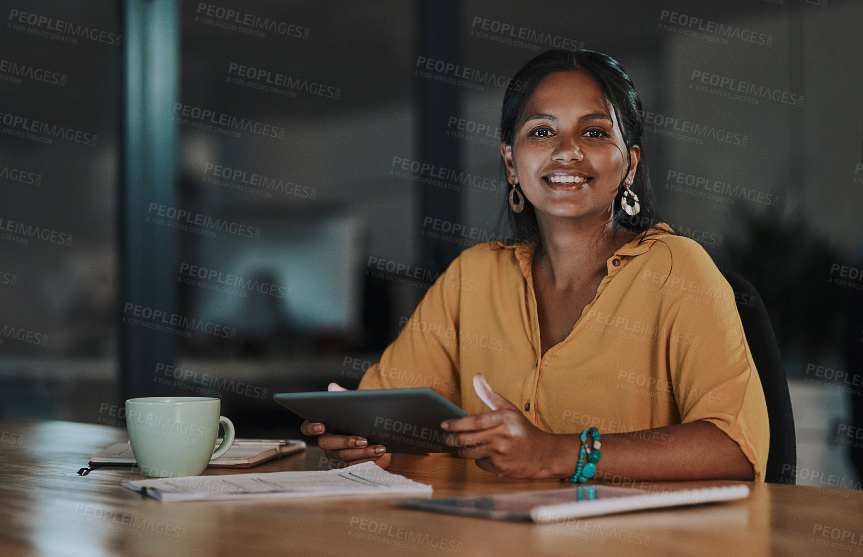 Buy stock photo Portrait of a young businesswoman using a digital tablet in an office at night