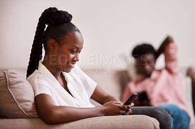 Buy stock photo Defocused of a woman using her cellphone while her partner sits in the background