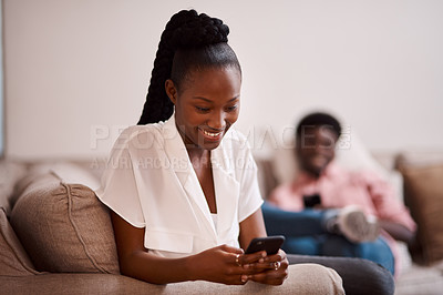 Buy stock photo Defocused of a woman using her cellphone while her partner sits in the background