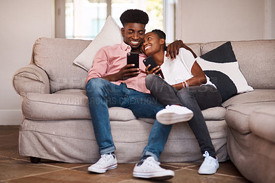Buy stock photo Shot of a couple using their cellphones while relaxing on the sofa at home