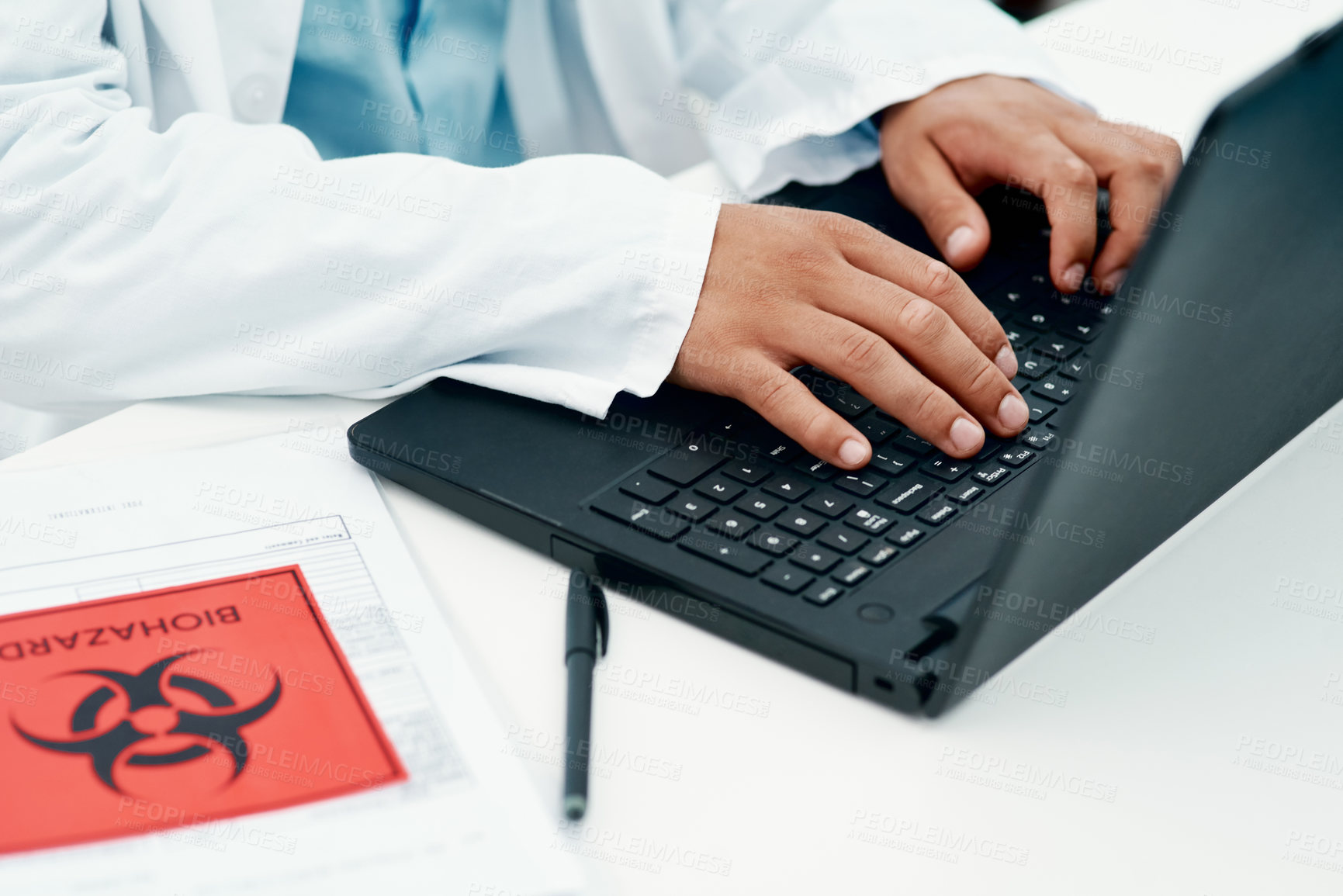 Buy stock photo Cropped shot of a scientist using a laptop while researching the coronavirus in a laboratory