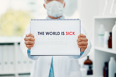 Buy stock photo Shot of a scientist holding a sign with “The world is sick” on it in a laboratory