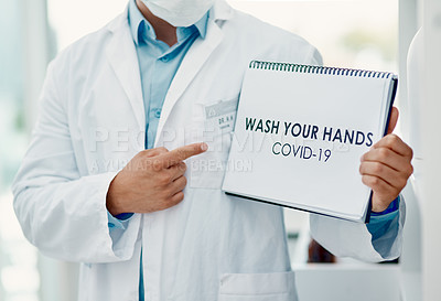 Buy stock photo Shot of a scientist holding a sign with “wash your hands” on it in a laboratory
