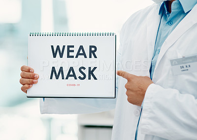 Buy stock photo Shot of a scientist holding a sign with “Wear mask” on it in a laboratory