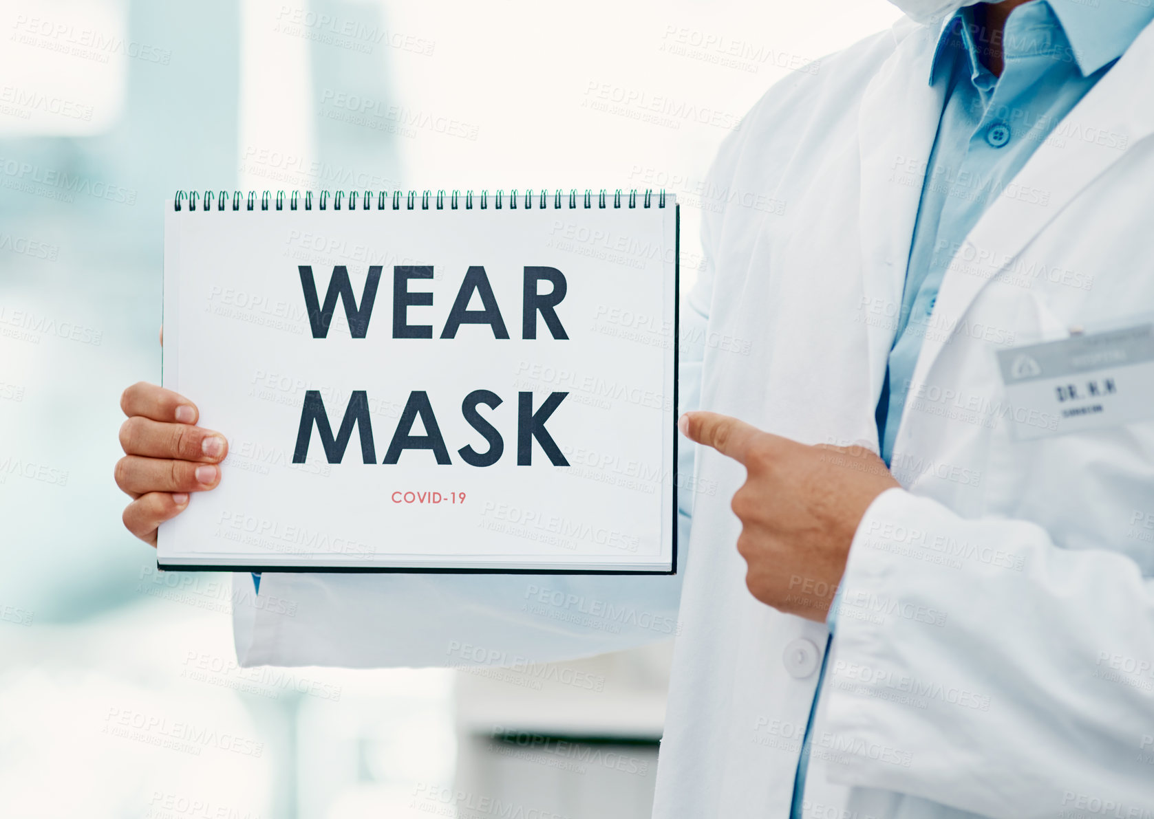 Buy stock photo Shot of a scientist holding a sign with “Wear mask” on it in a laboratory