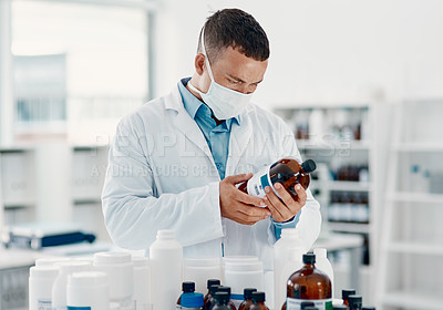 Buy stock photo Shot of a young scientist analysing medication in a laboratory