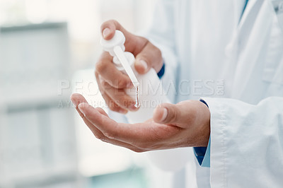 Buy stock photo Cropped shot of a scientist disinfecting his hands with hand sanitiser in a laboratory