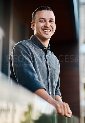 Buy stock photo Portrait of a confident young businessman standing on an office balcony