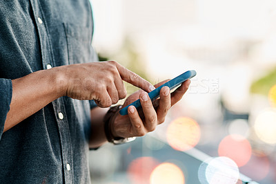 Buy stock photo Cropped shot of a businessman using a smartphone against a city background