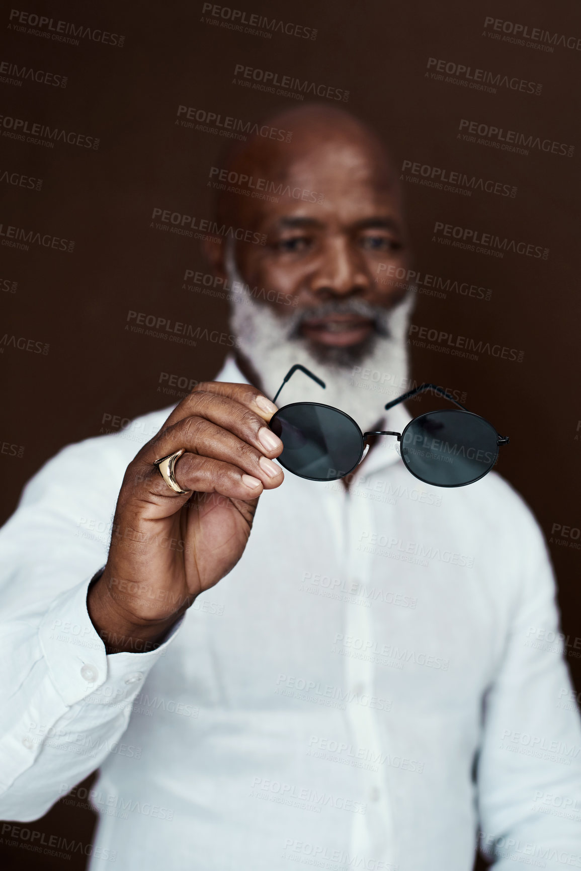 Buy stock photo Studio shot of a mature businessman posing against a brown background