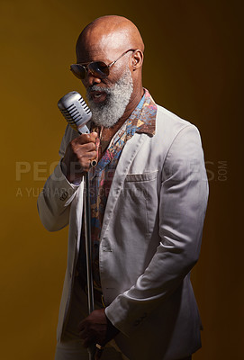 Buy stock photo Singer, senior and black man with soul, spotlight and old school music with retro style and microphone in studio. Musician, cool and singing with sunglasses in groovy fashion and colorful background