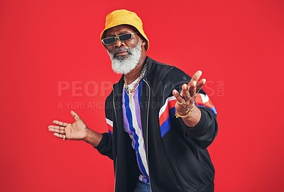 Buy stock photo Studio shot of a senior man wearing retro attire while posing against a red background