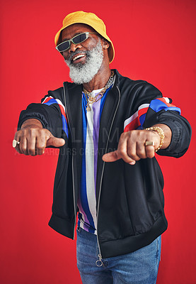 Buy stock photo Senior black man, fashion or cool rings with retro style for trendy casual outfit in studio on red background. Happy African person, confident or accessory for vintage clothes, attitude or sunglasses