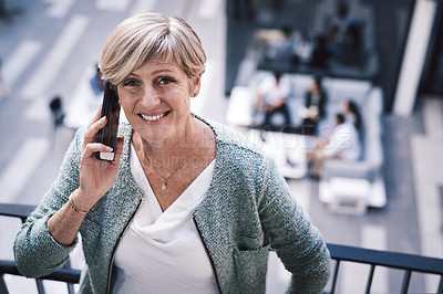 Buy stock photo Shot of a mature businesswoman using a smartphone on the stairs of a modern office