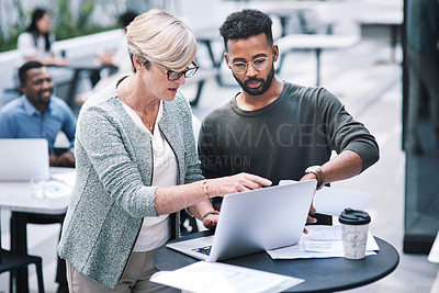 Buy stock photo Shot of a businessman and businesswoman using a laptop during a meeting at a convention centre