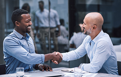 Buy stock photo Shot of two businessmen shaking hands during a meeting