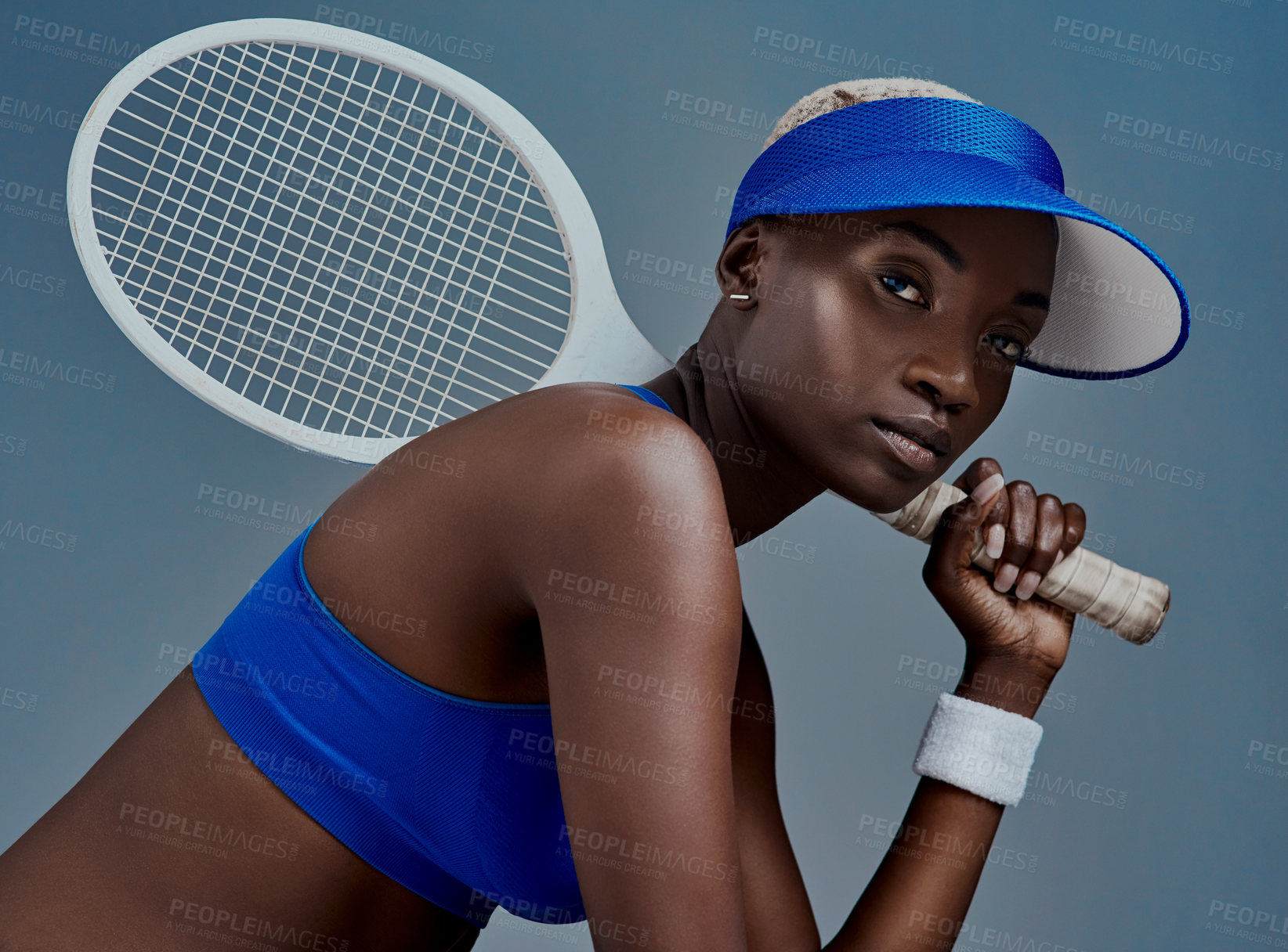 Buy stock photo Black woman, portrait and tennis racket in studio, sports confidence and practice on blue background. Female person, athlete and equipment for exercise fitness, training and workout for competition