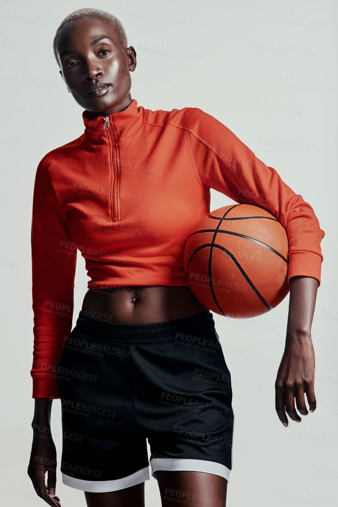 Buy stock photo Studio shot of an attractive young woman playing basketball against a grey background