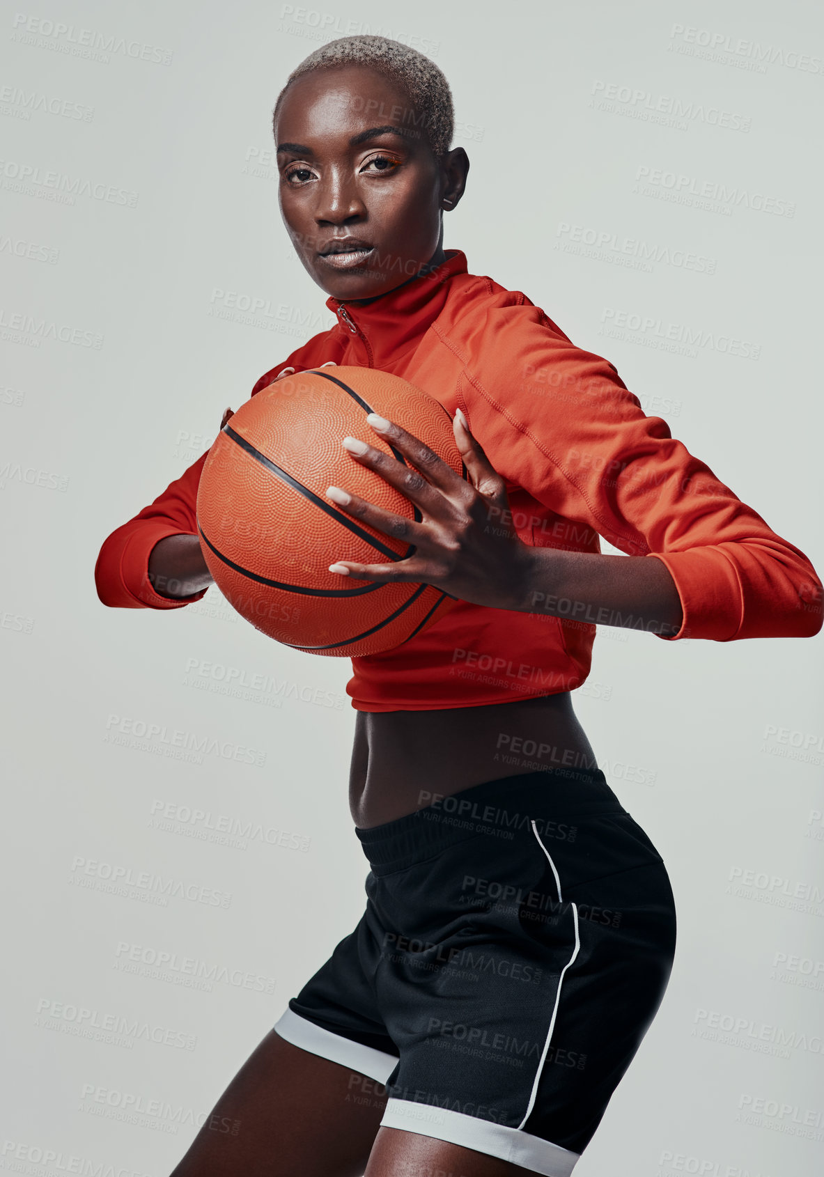 Buy stock photo Studio shot of an attractive young woman playing basketball against a grey background