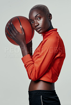 Buy stock photo Studio shot of an attractive young woman playing basketball against a grey background