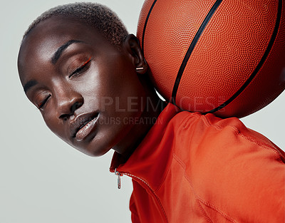 Buy stock photo Studio shot of an attractive young woman playing basketball against a grey background