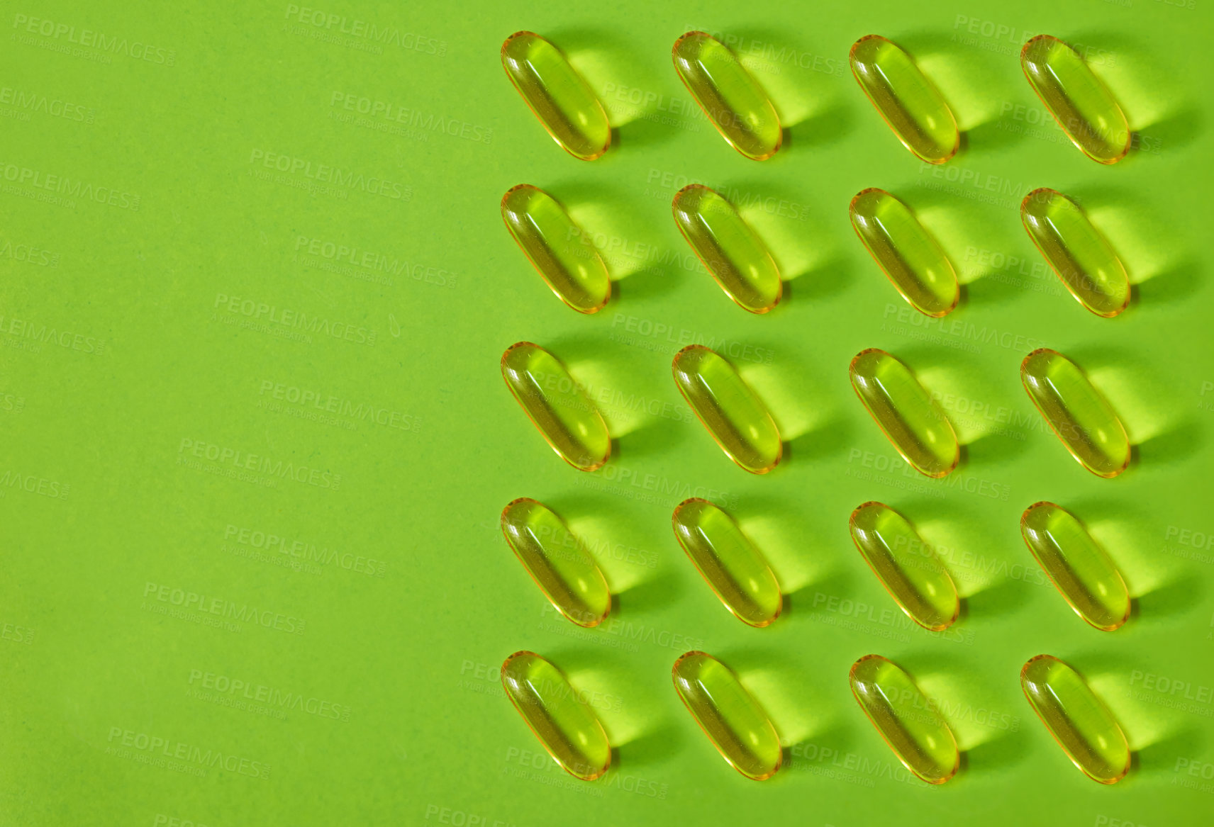 Buy stock photo Studio shot of gel capsules against a green background