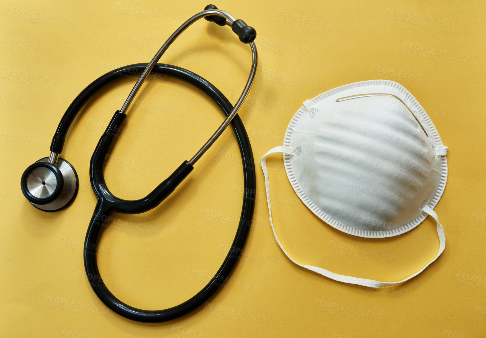 Buy stock photo Studio shot of a stethoscope and mask against a yellow background