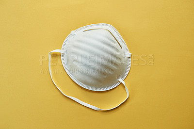 Buy stock photo Studio shot of a protective face mask against a yellow background