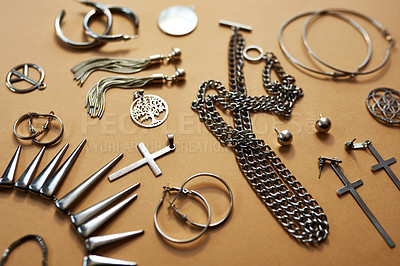Buy stock photo Studio shot of a selection of silver jewellery against a brown background