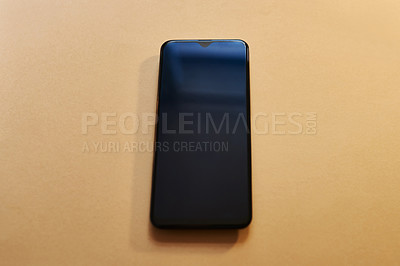 Buy stock photo Studio shot of a smartphone against a brown background